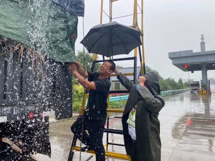 收费员雨中验货，摄影杨利芳