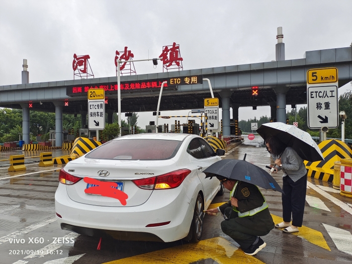 2021-9月19日，石安分公司河沙镇站雨中帮助司乘，摄影郭素玲